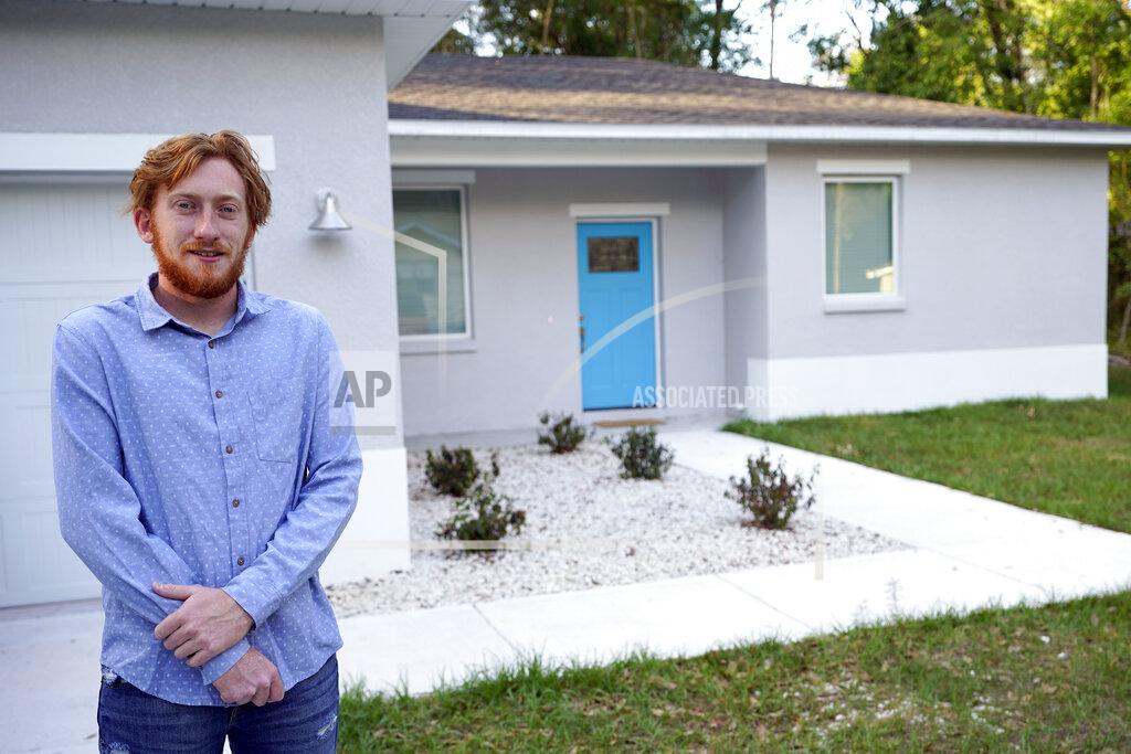 John Raoux First-time buyer Kevin Muglach stands in front of his new home, Tuesday, April 6, 2021, in Orange City, Fla. Homebuyers are facing the most competitive U.S. housing market in decades this spring, as surging prices and a record-low number of homes for sale narrow the already difficult path to home ownership for many Americans. (AP Photo/John Raoux)