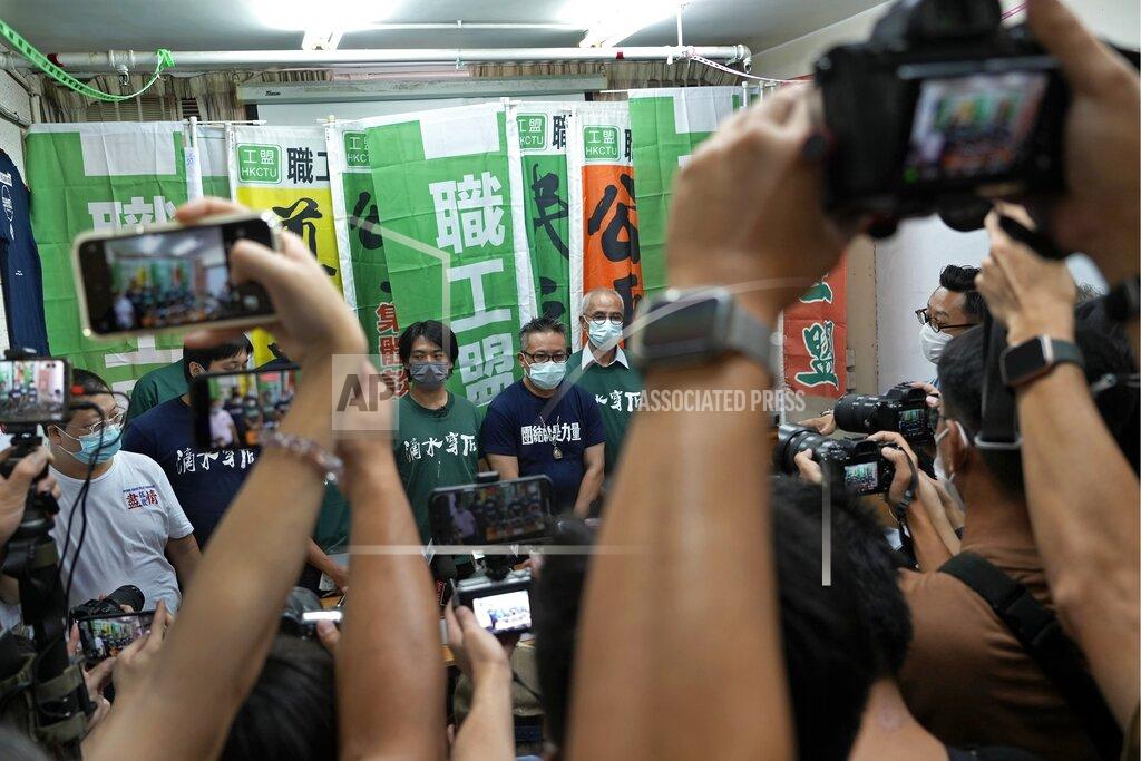 Vincent Yu Hong Kong Confederation of Trade Unions President Joe Wong Nai-yuen, center with deep blue T-shirt, poses with other members before a news conference on the possibility of disbandment in Hong Kong, Sunday, Sept. 19, 2021. (AP Photo/Vincent Yu)