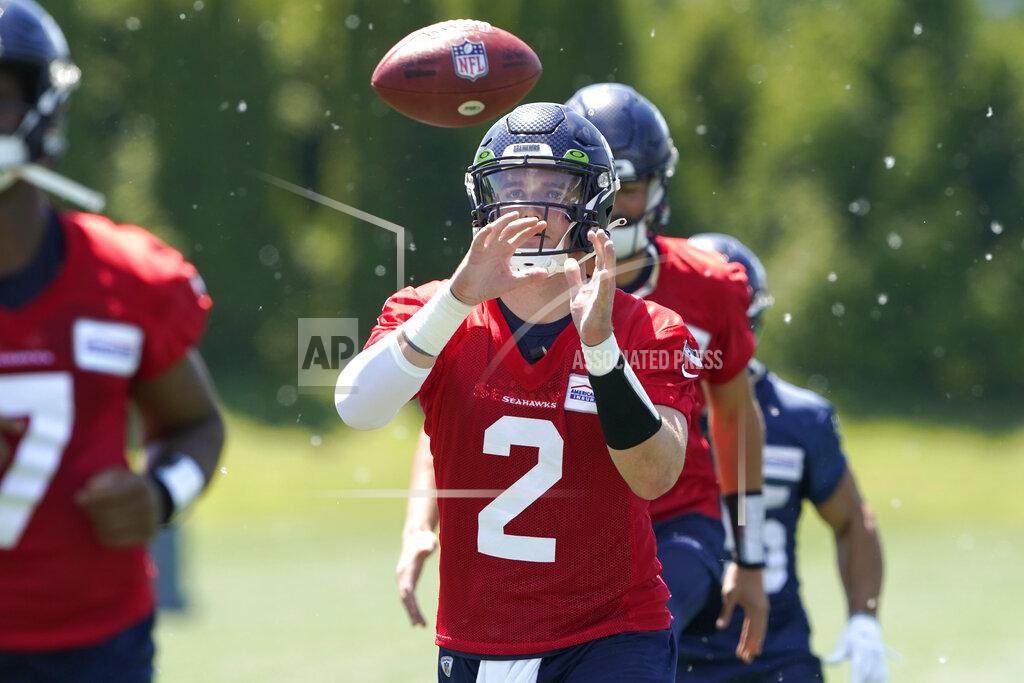 Ted S. Warren Seattle Seahawks quarterback Drew Lock reaches for the football during a drill at NFL football practice, Tuesday, May 31, 2022, in Renton, Wash. (AP Photo/Ted S. Warren)