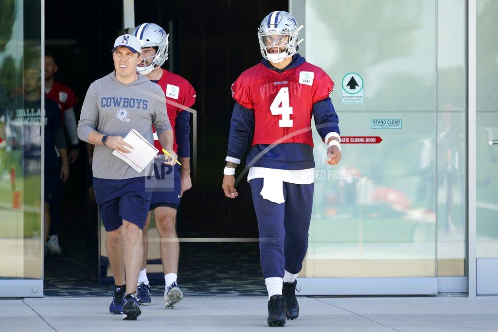 Tony Gutierrez Dallas Cowboys quarterback Dak Prescott (4) walks onto the field followed by offensive coordinator Kellen Moore and practice squad quarterback Ben DiNucci (3) at the team's NFL football training facility in Frisco, Texas, Thursday, Sept. 23, 2021. (AP Photo/Tony Gutierrez)
