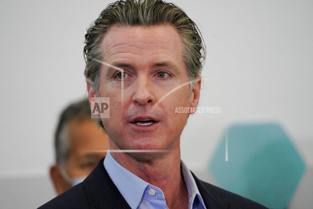 Governor Gavin Newsom speaks with news reporters at Park de la Cruz Recreation Center on Friday, April 2, 2021 in San Diego about the San Diego's newest pop-up vaccination site in the City Heights neighborhood. (Nelvin C. Cepeda/The San Diego Union-Tribune via AP)