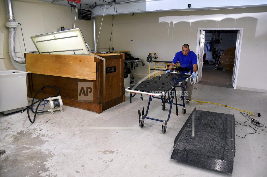Thomas Peipert In this Wednesday, Aug. 11, 2021, photo, Chris Olachia wheels a gurney through The Natural Funeral's human body composting facility in Arvada, Colo., on Wednesday, Aug. 11, 2021. On Sept. 7, Colorado became the second state after Washington to allow human body composting, and Oregon will allow the practice beginning next July. Vessels will be packed with wood chips and straw and will compost a body in six months. (AP Photo/Thomas Peipert)