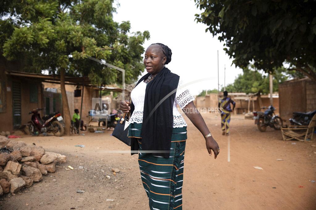 Sophie Garcia Mariama Sawadogo, 44, walks to her work as a radio host at Zama Radio, in Kaya, Burkina Faso, Monday, Oct. 25, 2021. Many guests and listeners in Burkina Faso call her "aunty" as she gently guides them to the right answers and awards prizes such as soap and washing buckets. In the West African country of Burkina Faso, many feel the government has let them down during the pandemic. Tests, vaccines and messaging often miss many residents, despite a $200 million budget for virus-response efforts. In a region where women are responsible for family work and community relationships, they’ve stepped up to fill in gaps. (AP Photo/Sophie Garcia)