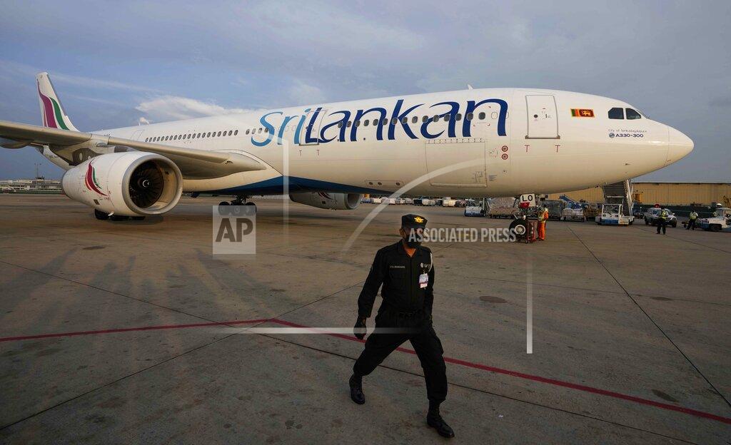 Eranga Jayawardena A Sri Lankan Airlines plane carrying remains of Priyantha Kumara, a Sri Lankan employee who was lynched by a Muslim mob in Sialkot arrives as a security officers guards the area in Colombo, Sri Lanka, Dec. 6, 2021. Sri Lanka’s prime minister on Monday proposed to privatize the country’s loss-making national carrier as part of reforms to solve the country worst economic crisis in recent memory. (AP Photo/Eranga Jayawardena, File)