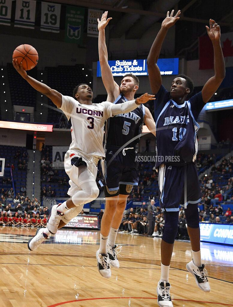 Jessica Hill Connecticut's Alterique Gilbert shoots as Maine's Nedeljko Prijovic, center, and Maine's Stephane Ingo defend, right, during the first half of an NCAA college basketball game, Sunday, Dec. 1, 2019, in Hartford, Conn. (AP Photo/Jessica Hill)