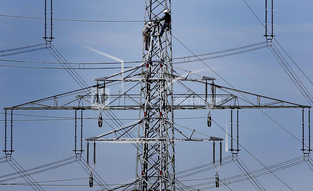 Frank Augstein FILE - In this Monday, April 11, 2011 file photo, workers of the German energy company RWE prepare power supply on a high power pylon in Moers, Germany. Almost 3 million European workers can't afford to heat their houses amid rise in energy prices, according to a labor organization's study released Wednesday Sept. 22, 2021. (AP Photo/Frank Augstein, File)