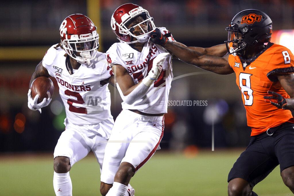 Ian Maule Oklahoma wide receiver CeeDee Lamb (2) runs after a catch while wide receiver Lee Morris (84) blocks Oklahoma State cornerback Rodarius Williams (8) during an NCAA college football game, Saturday, Nov. 30, 2019, in Stillwater, Okla. (Ian Maule/Tulsa World via AP)