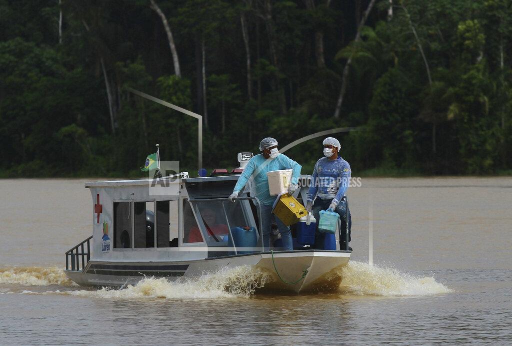 Edmar Barros Healthcare workers Diego Feitosa Ferreira, 28, right, and Clemilton Lopes de Oliveira, 41, travel on a boat to the Santa Rosa community, Amazonas state, Brazil, Friday, Feb. 12, 2021, to vaccinate residents with the AstraZeneca COVID-19 vaccine. Getting the vaccine to the villages was important since most jungle communities have only basic medical facilities that aren't equipped to treat severe COVID-19 cases. (AP Photo/Edmar Barros)