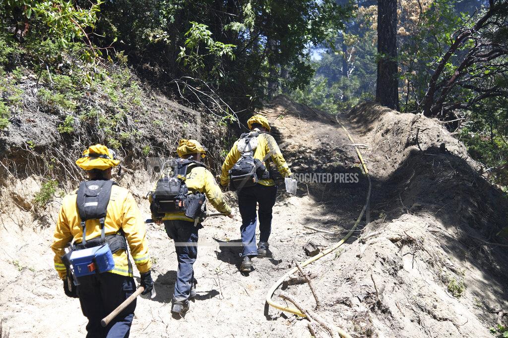 Elias Funez Firefighters travel a line cut by a dozer to help secure the Golden Fire off of Highway 49 south of Camptonville, Calif. Friday, May 20, 202. (Elias Funez/The Union via AP)