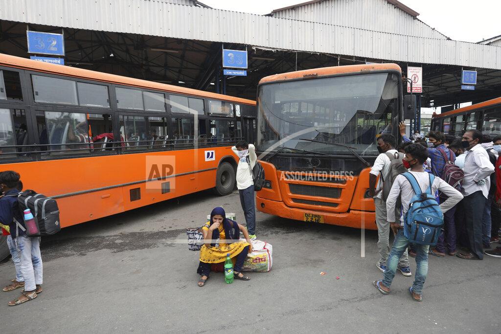 Manish Swarup Migrant workers wait for transportation after having their COVID-19 tests done upon arrival in New Delhi, India, Tuesday, Aug. 18, 2020. The lockdown imposed in late March cost more than 10 million impoverished migrant workers their jobs in the cities. Many made grueling journeys back to their hometowns and villages. Now they face the ordeal of trying to get back to their factory jobs. (AP Photo/Manish Swarup)