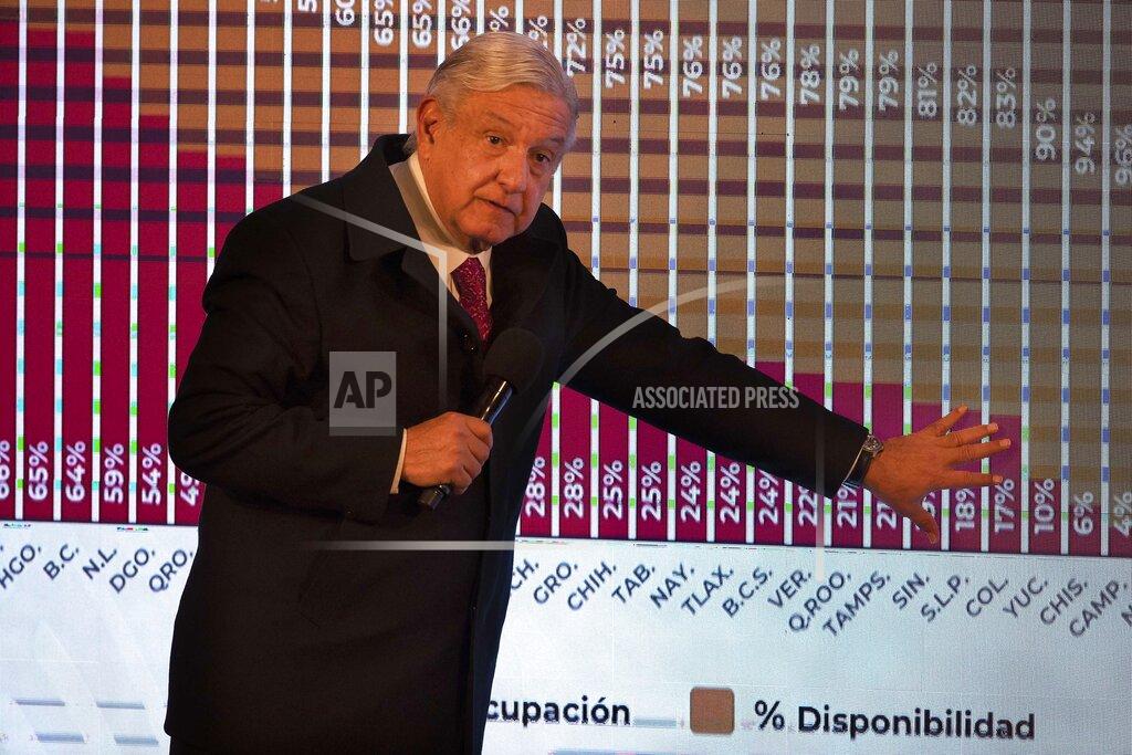 FILE - In this Dec. 18, 2020 file photo, Mexican President Andres Manuel Lopez Obrador points to a graph showing the percentages of hospital beds available, state by state, during his daily news conference at the presidential palace, Palacio Nacional, in Mexico City. López Obrador was working from isolation on Monday, Jan. 25, 2021, a day after announcing that he had tested positive for COVID-19, his interior secretary said. (AP Photo/Marco Ugarte, File)