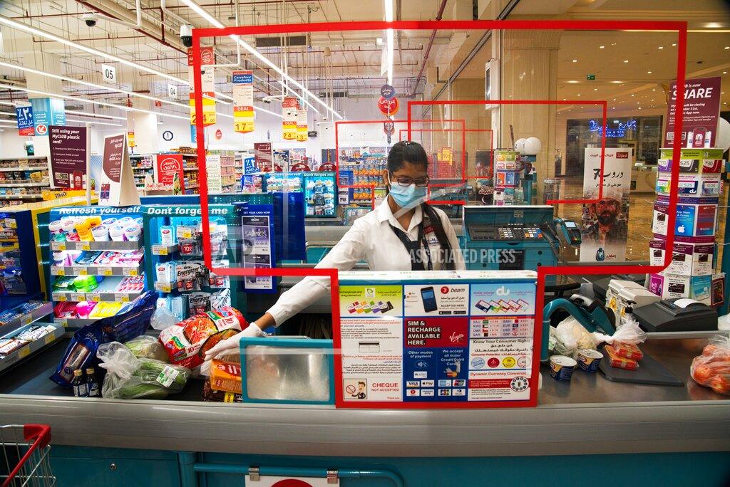 Jon Gambrell In this April 19, 2020 photo, cashier Valancy Fernandes of India, wearing a surgical mask and gloves to help prevent the spread of coronavirus, works at a Carrefour supermarket in Dubai, United Arab Emirates. Frontline workers across Arab Gulf countries are uniquely almost entirely foreigners. They risk exposure to the novel coronavirus, ensuring patients are cared for, streets are sanitized, packages are delivered and grocery stores are stocked. The global pandemic has drawn attention to just how vital foreigners are to the Arab Gulf countries where they work. (AP Photo/Jon Gambrell)