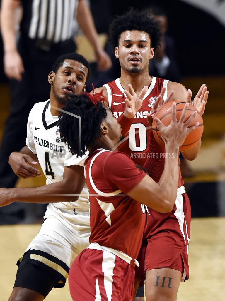 Mark Zaleski Arkansas forward Justin Smith (0) passes the ball to guard Davonte Davis (4) as Vanderbilt guard Jordan Wright (4) defends during the first half of an NCAA college basketball game Saturday, Jan. 23, 2021, in Nashville, Tenn. (AP Photo/Mark Zaleski)
