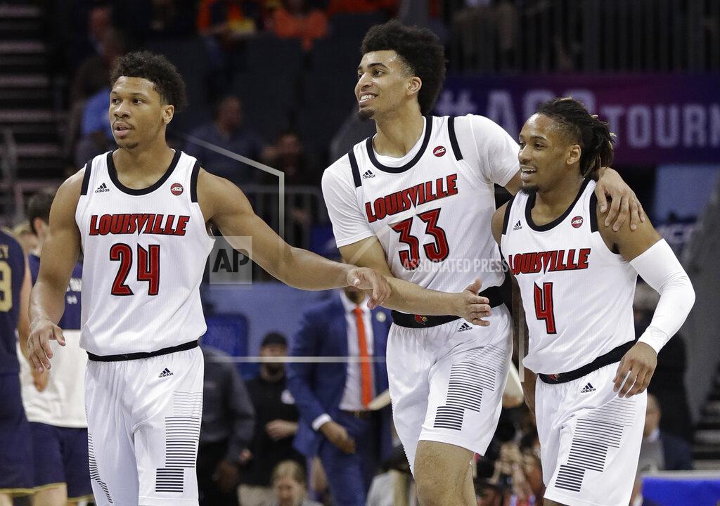 Chuck Burton Louisville's Khwan Fore (4), Jordan Nwora (33) and Dwayne Sutton (24) celebrate in a timeout during the second half of an NCAA college basketball game in the Atlantic Coast Conference tournament in Charlotte, N.C., Wednesday, March 13, 2019. (AP Photo/Chuck Burton)