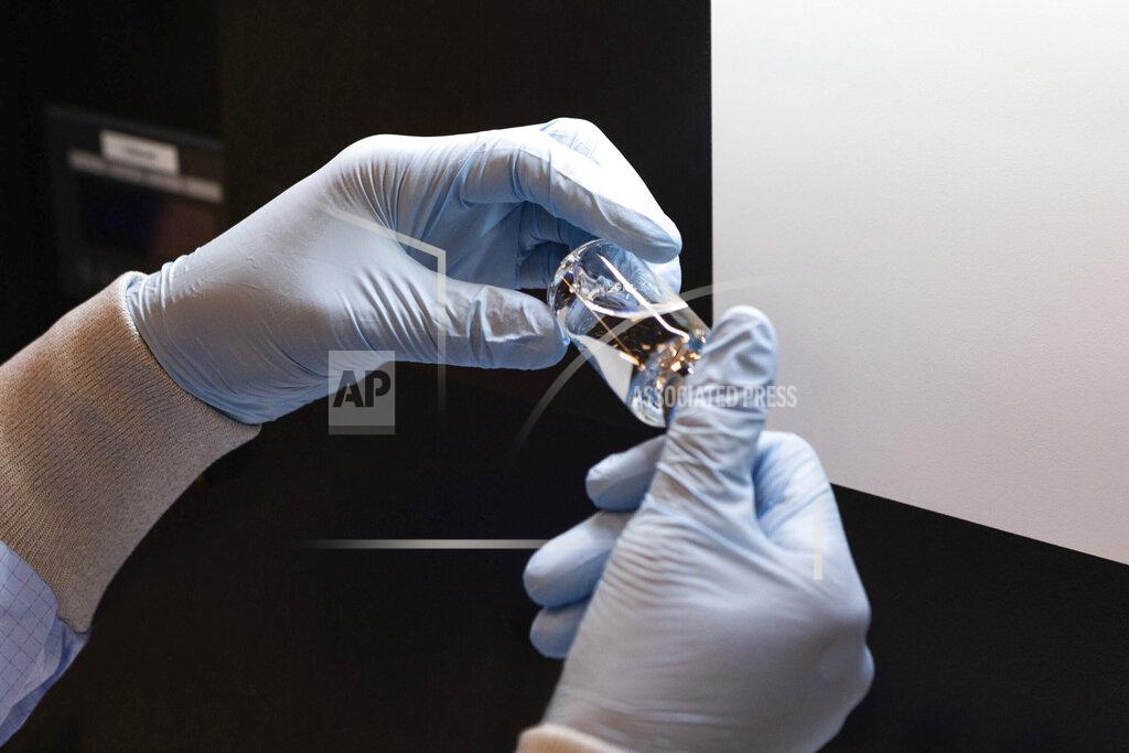 In this March 2020 photo provided by Gilead Sciences, a vial of the investigational drug remdesivir is visually inspected at a Gilead manufacturing site in the United States. Given through an IV, the medication is designed to interfere with an enzyme that reproduces viral genetic material. (Gilead Sciences via AP)