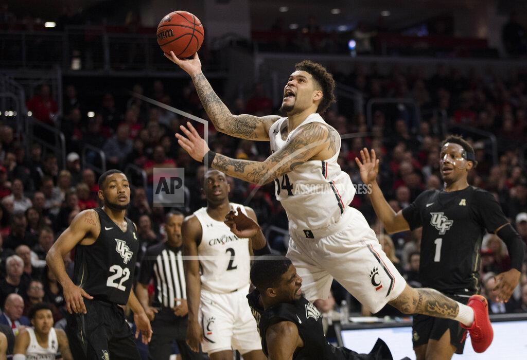 Albert Cesare Cincinnati guard Jarron Cumberland (34) shoots as Central Florida forward Collin Smith (35) is charged with a blocking foul during the second half of an NCAA college basketball game Wednesday, Feb. 19, 2020, in Cincinnati. (Albert Cesare/The Cincinnati Enquirer via AP)