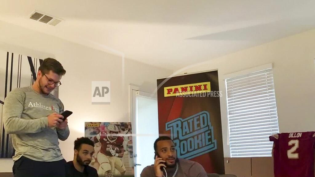 Uncredited In this still image from video provided by the NFL, AJ Dillon, right, talks on the phone during the second round of the NFL football draft, Friday, April 24, 2020. Dillon was selected by the Green Bay Packers. (NFL via AP)