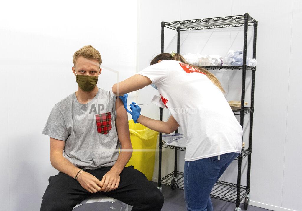 Dominic Lipinski A man receives a dose of a COVID-19 vaccine, at a mass coronavirus vaccination centre held in Arsenal's Emirates Stadium, in north London, Friday June 25, 2021. (Dominic Lipinski/PA via AP)