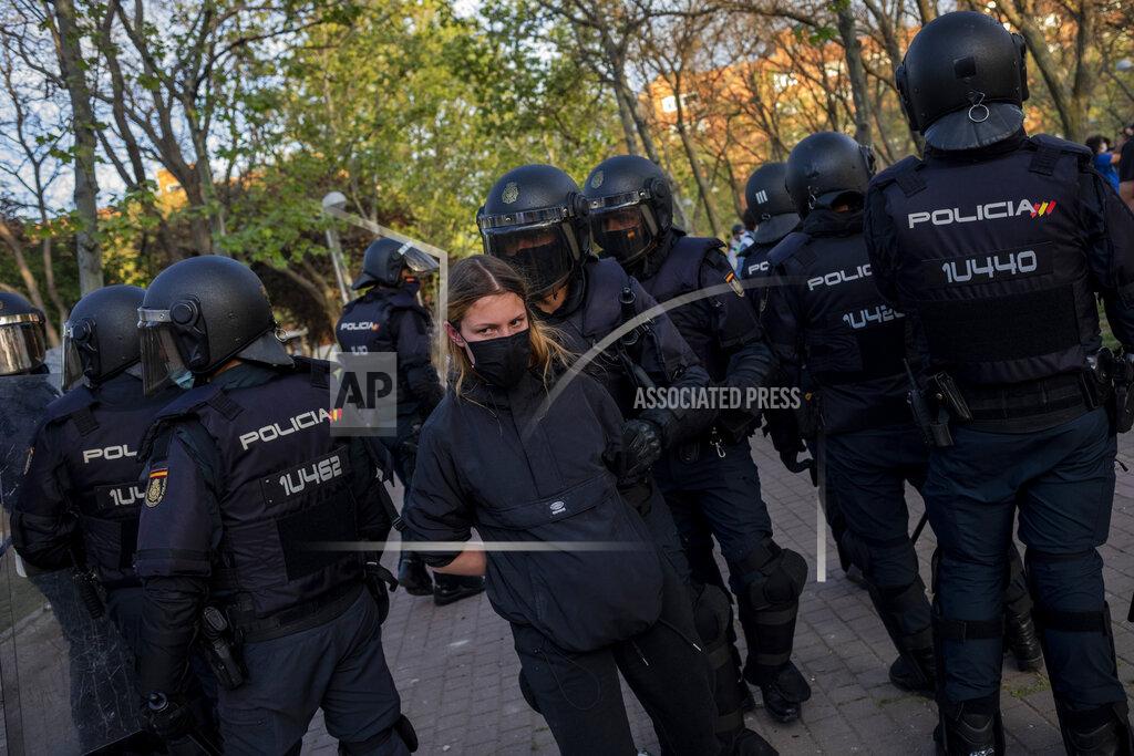 Bernat Armangue Spanish police detain a left-wing protester in Madrid's Vallecas neighborhood, Spain, Wednesday, April 7, 2021. Spanish police have used batons to keep protesters away from a campaign event of the far-right Vox party in Madrid. Scuffles started Wednesday when Santiago Abascal, the national leader of Vox, approached a crowd gathered to protest the party rally in Madrid's Vallecas neighborhood, a traditional left-wing bastion. Riot peace charged the bunches of protesters to keep them away from the party campaign event for upcoming regional elections. (AP Photo/Bernat Armangue)