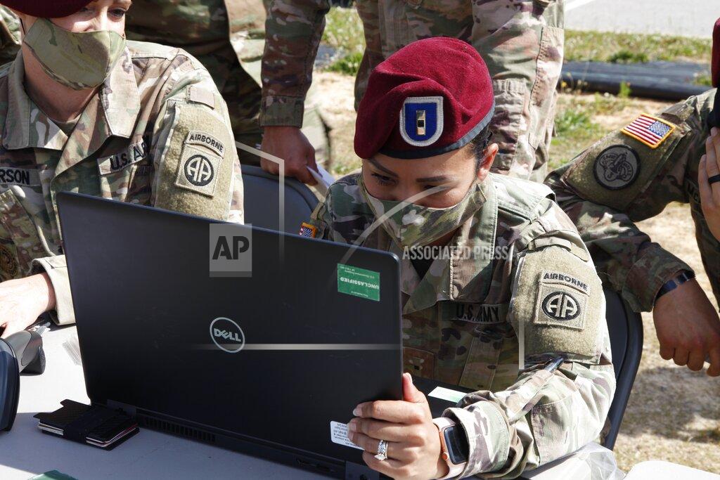 Sarah Blake Morgan In this Friday, May 15, 2020 photo, a Fort Bragg, North Carolina paratrooper checks off deploying soldiers' names on a computer. 2,200 members of the 82nd Airborne's 2nd Brigade Combat Team will be deploying to the Middle East for nine months amid the Coronavirus pandemic. (AP Photo/Sarah Blake Morgan)