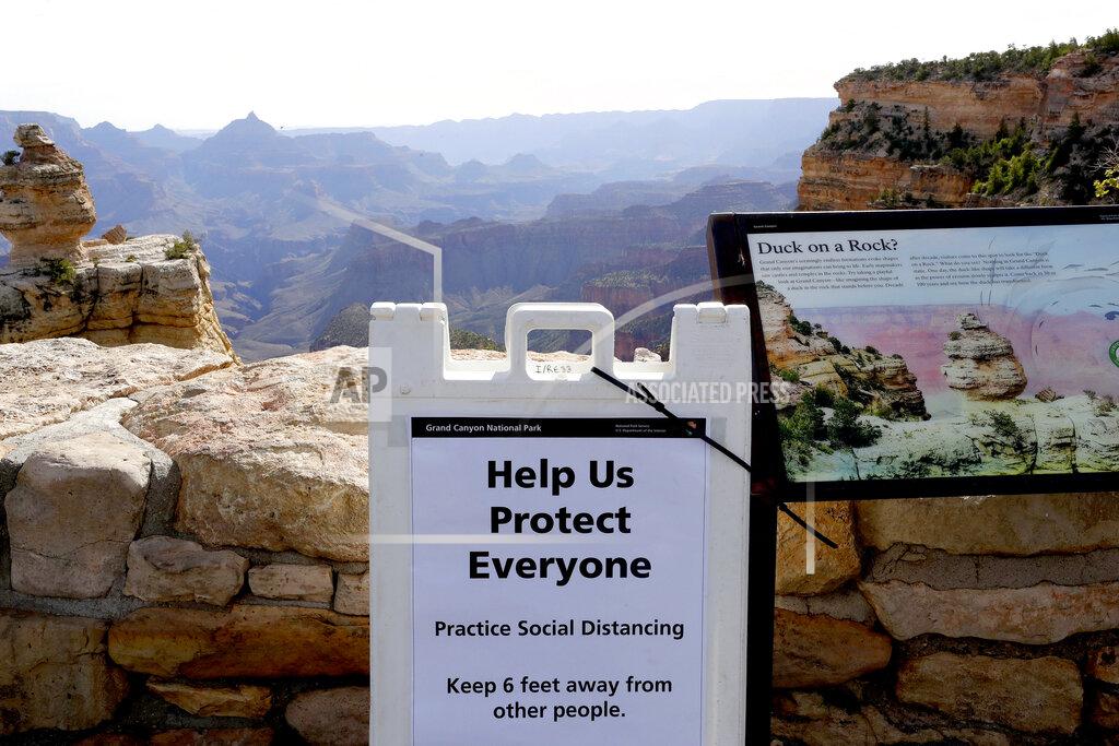 Matt York A social distancing sign is seen at the Grand Canyon Friday, May 15, 2020, in Grand Canyon, Ariz. Tourists are once again roaming portions of Grand Canyon National Park when it partially reopened Friday morning, despite objections that the action could exacerbate the coronavirus pandemic. (AP Photo/Matt York)