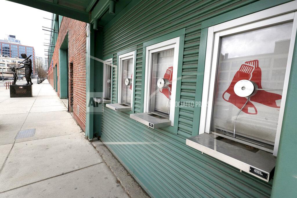 Steven Senne Ticket windows are closed at Fenway Park baseball park, Wednesday, March 25, 2020, in Boston. There will be empty ballparks on what was supposed to be Major League Baseball's opening day, with the start of the Major League Baseball regular season indefinitely on hold because of the coronavirus pandemic. A statue of former Red Sox player Ted Williams stands at left. (AP Photo/Steven Senne)