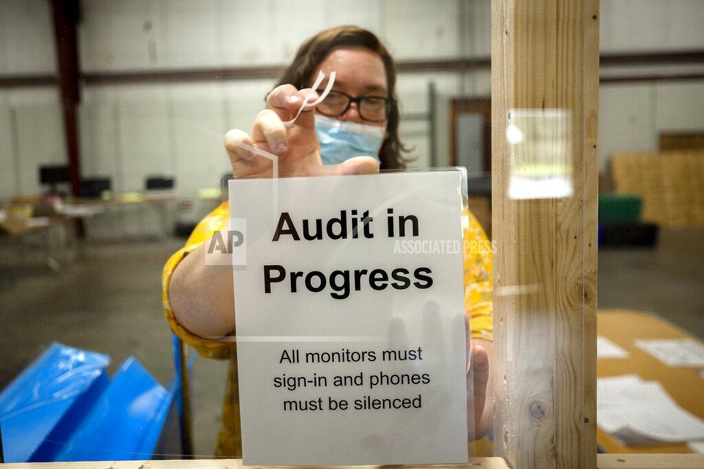 Stephen B. Morton A Chatham County election official posts a sign in the public viewing area before the start of a ballot audit, Friday, Nov. 13, 2020, in Savannah, Ga. Election officials in Georgia’s 159 counties are undertaking a hand tally of the presidential race that stems from an audit required by state law. (AP Photo/Stephen B. Morton)
