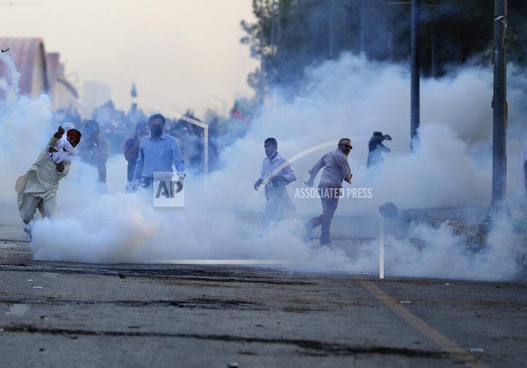 Rahmat Gul Police use tear gas to disperse supporters of Pakistan's key opposition party marching in Islamabad, Pakistan, Wednesday, May 25, 2022. Pakistani authorities blocked off all major roads into the capital Islamabad on Wednesday, after a defiant former Prime Minister Imran Khan said he would march with demonstrators to the city center for a rally he hopes will bring down the government and force early elections. (AP Photo/Rahmat Gul)