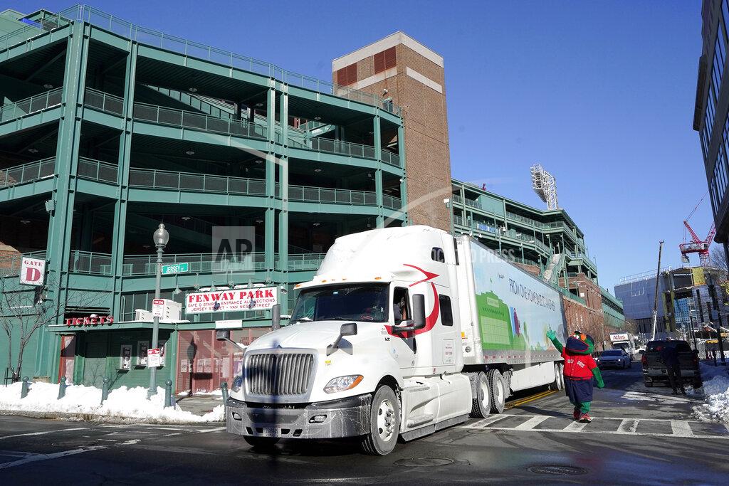 Steven Senne Wally the Green Monster, the team's mascot, right, waves as a Boston Red Sox baseball equipment truck departs Fenway Park, Monday, Feb. 8, 2021, in Boston on its way to the team's spring training facility, in Fort Myers, Fla. (AP Photo/Steven Senne)
