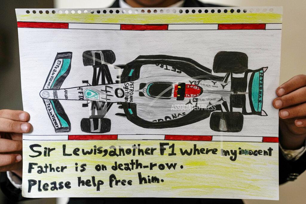 Uncredited Ahmed, 12 years old, son of Mohammed Ramadhan, a former member of Bahrain's security forces who is facing the death penalty in Bahrain, holds a drawing he made of F1 driver Lewis Hamilton's Formula One car in Manama, Bahrain, Thursday, March 17, 2022. Ahead of Sunday's season-opening F1 race in Bahrain, Ahmed proudly held up the drawing of Hamilton's famed No. 44 Mercedes car along with his own words of hope: "Sir Lewis, another F1 where my innocent father is on death row. Please help free him." (AP Photo)