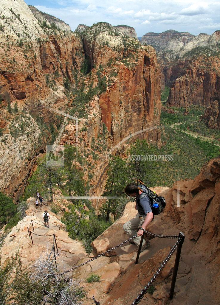 Jud Burkett FILE - In this May 8, 2011, file photo, hikers climb down the Angels Landing trail in Zion National Park, in Utah. Zion National Park announced Monday, March 23, 2020, it is closing its campgrounds and part of a popular trail called Angel's Landing that is often crowded with people due to coronavirus. The top part of the hike that is being closed is bordered by steep drops and ascends some 1,500 feet (457 meters) above the southern Utah park's red-rock cliffs, offering sweeping views. (Jud Burkett/The Spectrum via AP, File)