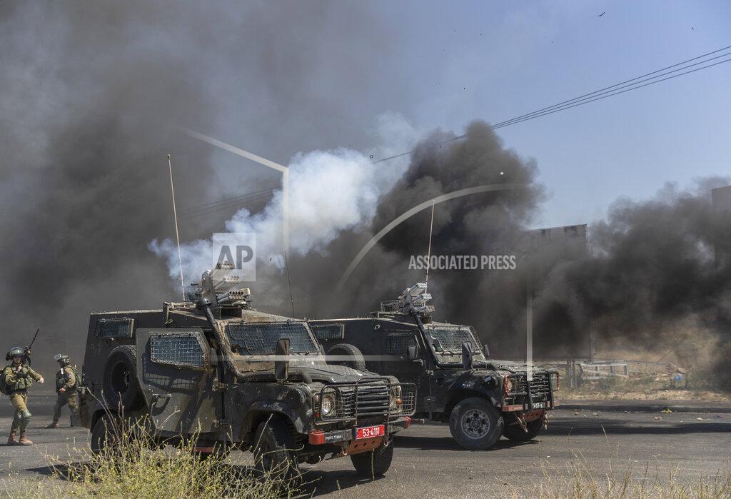 Nasser Nasser Israeli army vehicles fire teargas canisters toward Palestinian protesters during clashes at the northern entrance of the West Bank city of Ramallah, Friday, May 14, 2021. Palestinian health officials said that several Palestinians were killed by Israeli army fire during protests that took place in several locations across the West Bank on Friday. (AP Photo/Nasser Nasser)