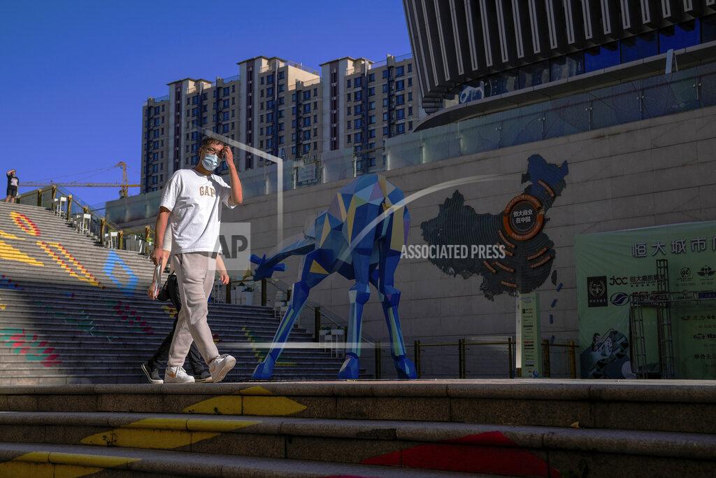 Andy Wong A man wearing a face mask to help protect himself from the coronavirus walks by a map showing the Evergrande development projects in China, at an Evergrande city plaza in Beijing, Tuesday, Sept. 21, 2021. Global investors are watching nervously as the Evergrande Group, one of China's biggest real estate developers, struggles to avoid defaulting on tens of billions of dollars of debt, fueling fears of possible wider shock waves for the Chinese financial system. (AP Photo/Andy Wong)