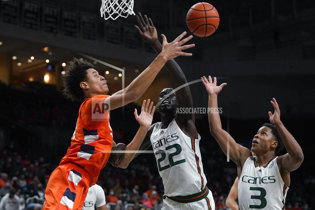 Wilfredo Lee Syracuse center Jesse Edwards, left, passes past Miami forward Deng Gak (22) and guard Charlie Moore (3) during the first half of an NCAA college basketball game, Wednesday, Jan. 5, 2022, in Coral Gables, Fla. (AP Photo/Wilfredo Lee)