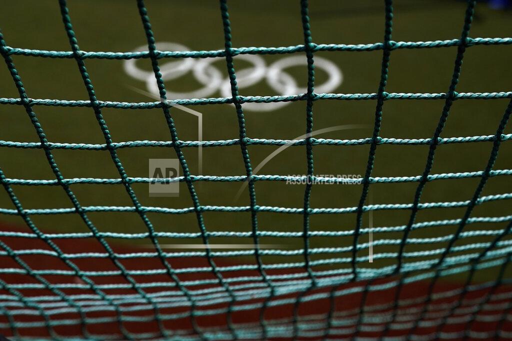 Jae C. Hong The Olympic rings painted on the field are seen through a net as U.S. softball players take batting practice at the Fukushima Azuma Baseball Stadium ahead of the 2020 Summer Olympics, Tuesday, July 20, 2021, in Fukushima, Japan. (AP Photo/Jae C. Hong)