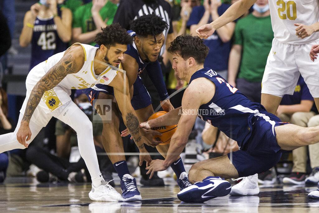 Robert Franklin Notre Dame's Prentiss Hubb, left, scrambles for the ball with Virginia's Jayden Gardner, center, and Francisco Caffaro during the second half of an NCAA college basketball game Saturday, Jan. 29, 2022, in South Bend, Ind. (AP Photo/Robert Franklin)