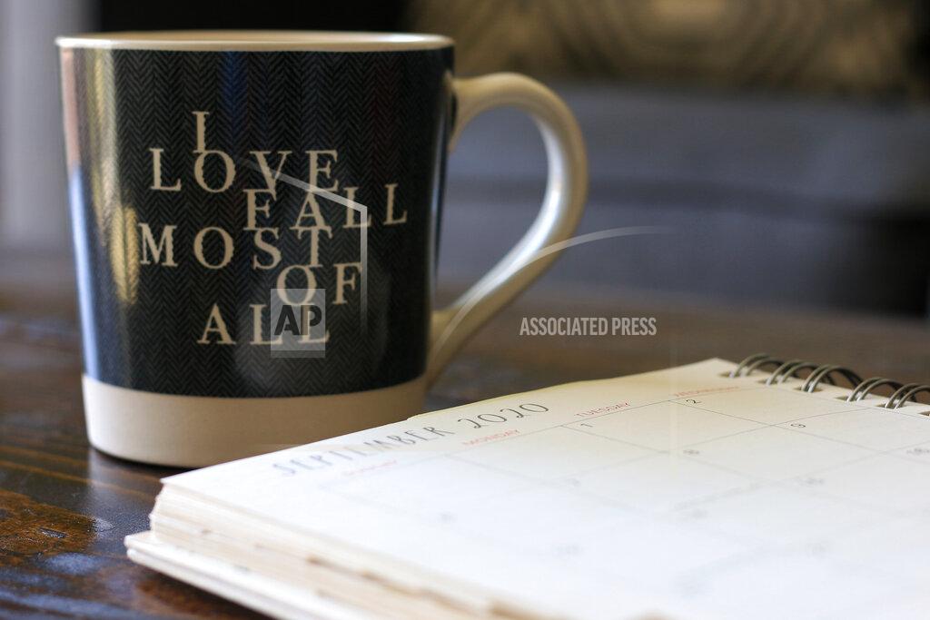 Associated Press journalist Cheyanne Mumphrey opens her planner to the month of September with a cup of hot chocolate in her studio in downtown Phoenix on Sept. 1, 2020. (AP Photo/Cheyanne Mumphrey)