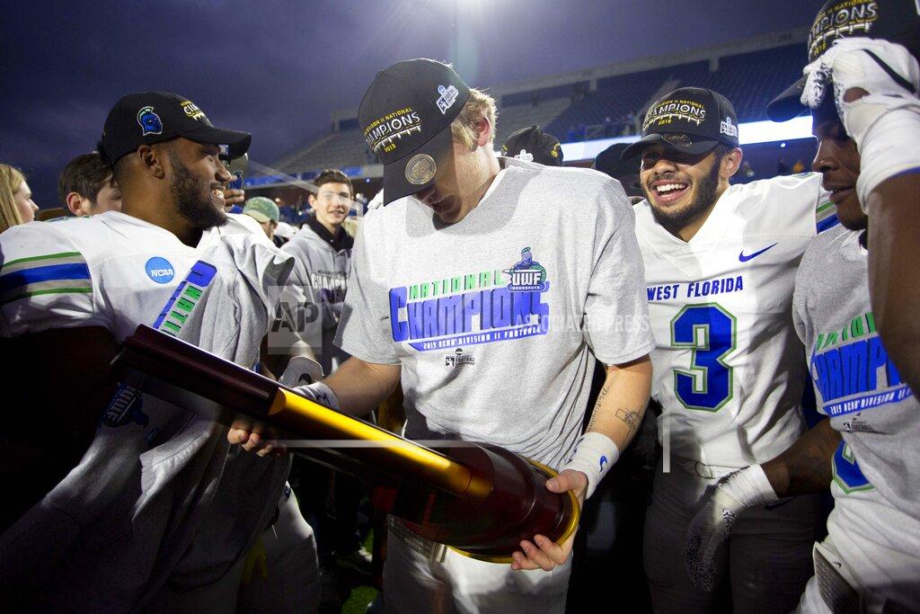 West Florida quarterback Austin Reed, center, holds the trophy while celebrating with teammates after the team won the Division II championship NCAA college football game against Minnesota State, Saturday, Dec. 21, 2019, in McKinney, Texas. (AP Photo/Gareth Patterson)