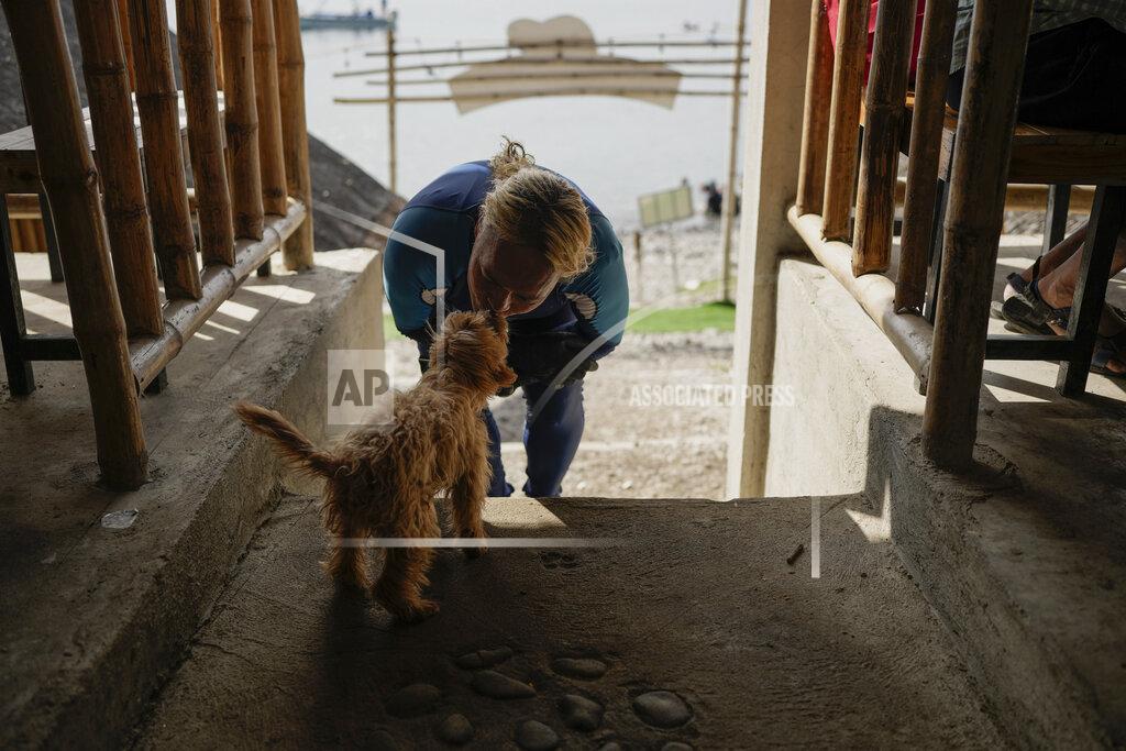 Aaron Favila Queen Pangke Tabora kisses her dog "Choknut" before teaching freediving and mermaiding classes at the Ocean Camp in Mabini, Batangas province, Philippines on Saturday, May 21, 2022. (AP Photo/Aaron Favila)