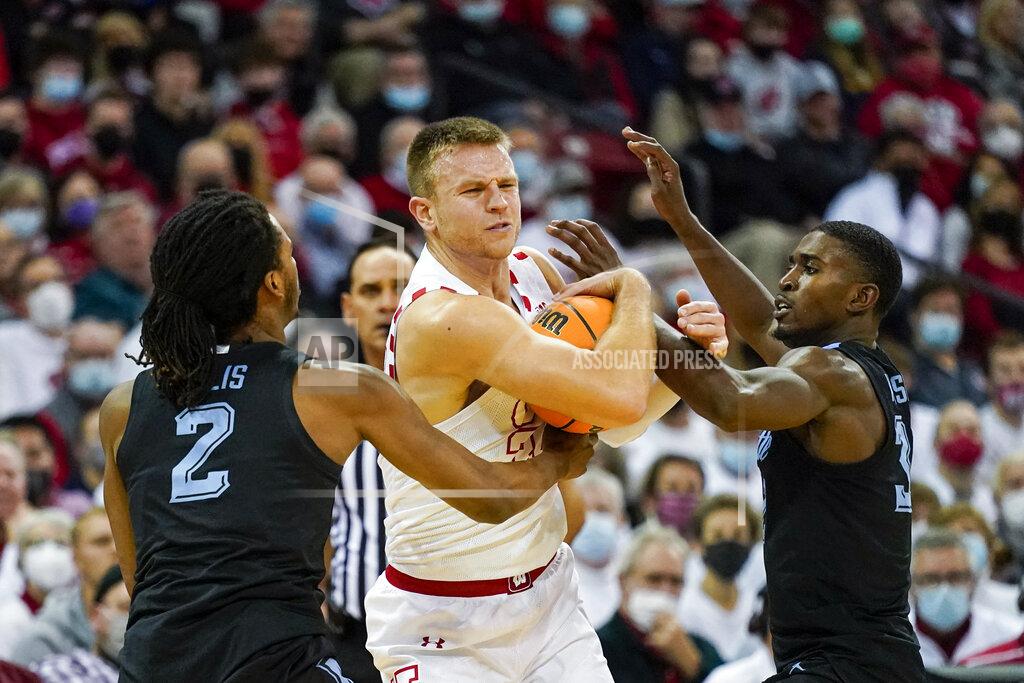 Andy Manis Wisconsin's Brad Davison, center, battles against Marquette's Emarion Ellis (2) and Darryl Morsell during the second half of an NCAA college basketball game Saturday, Dec. 4, 2021, in Madison, Wis. Wisconsin won 89-76. (AP Photo/Andy Manis)
