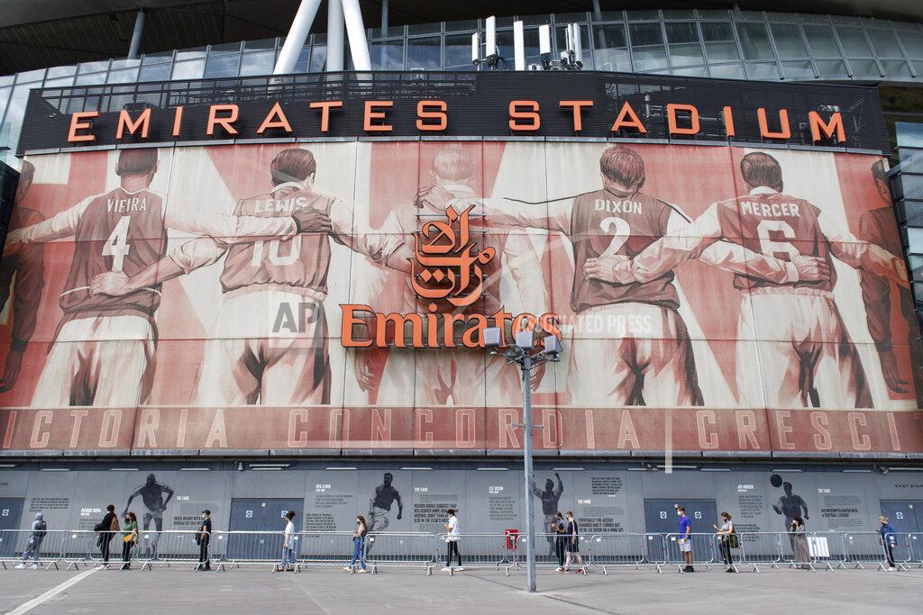 Dominic Lipinski People queue at a mass coronavirus vaccination centre held in Arsenal's Emirates Stadium, in north London, Friday June 25, 2021. (Dominic Lipinski/PA via AP)