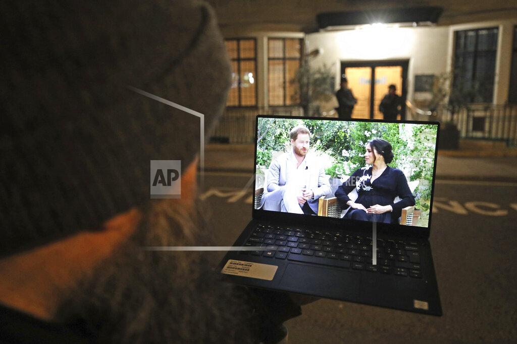 Yui Mok A man watches his laptop showing an interview of Prince Harry and Meghan, The Duchess of Sussex, by Oprah Winfrey outside King Edward VII's Hospital where the Duke of Edinburgh has been transferred from a specialist cardiac hospital to a private facility to continue his recovery after a heart procedure, in London Monday, March 8, 2021. (Yui Mok/PA via AP)