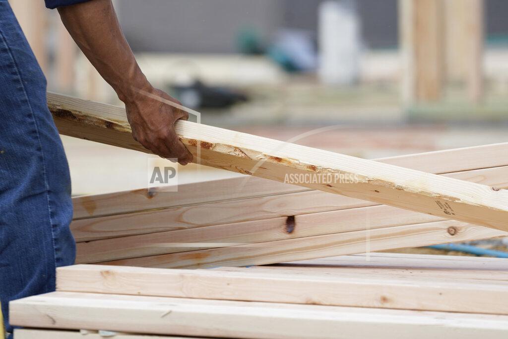 Rogelio V. Solis A workman arranges a beam on a frame at a new housing site in Madison County, Miss., Tuesday, March 16, 2021. Rising prices for a variety of commodities are contributing to a jump in prices at the consumer level, with Americans paying more for meat, gasoline, items they keep in their homes and even the homes themselves.(AP Photo/Rogelio V. Solis)