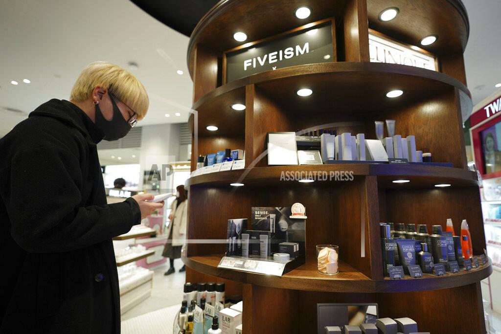 Customer Kenta Yamazaki, a 24-year-old hairdresser, looks at beauty products at @cosme TOKYO, a store selling a selection of cosmetics and makeup products including men's cosmetic, in Tokyo's Harajuku district Tuesday, Feb. 9, 2021. The coronavirus pandemic has been pushing businesses to the edge in Japan, but some in the men's beauty industry have seen an unexpected expansion in their customer base. Japanese businessmen in their 40s, 50s and 60s who had little interest in cosmetics before the pandemic are now buying makeup. (AP Photo/Eugene Hoshiko)