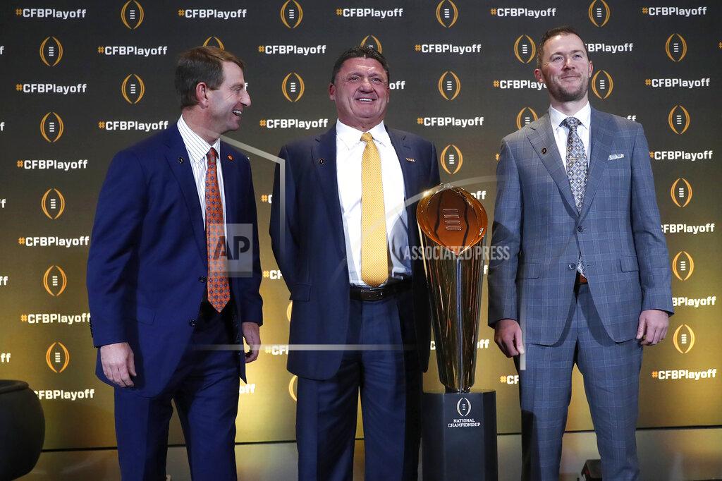Clemson head coach Dabo Swinney, left, jokes with LSU head coach Ed Orgeron and Oklahoma head coach Lincoln Riley, right, as they pose with the College Football Championship trophy during a news conference ahead for the College Football playoffs Thursday, Dec. 12, 2019, in Atlanta. Ryan Day of Ohio State was unable to attend. (AP Photo/John Bazemore)