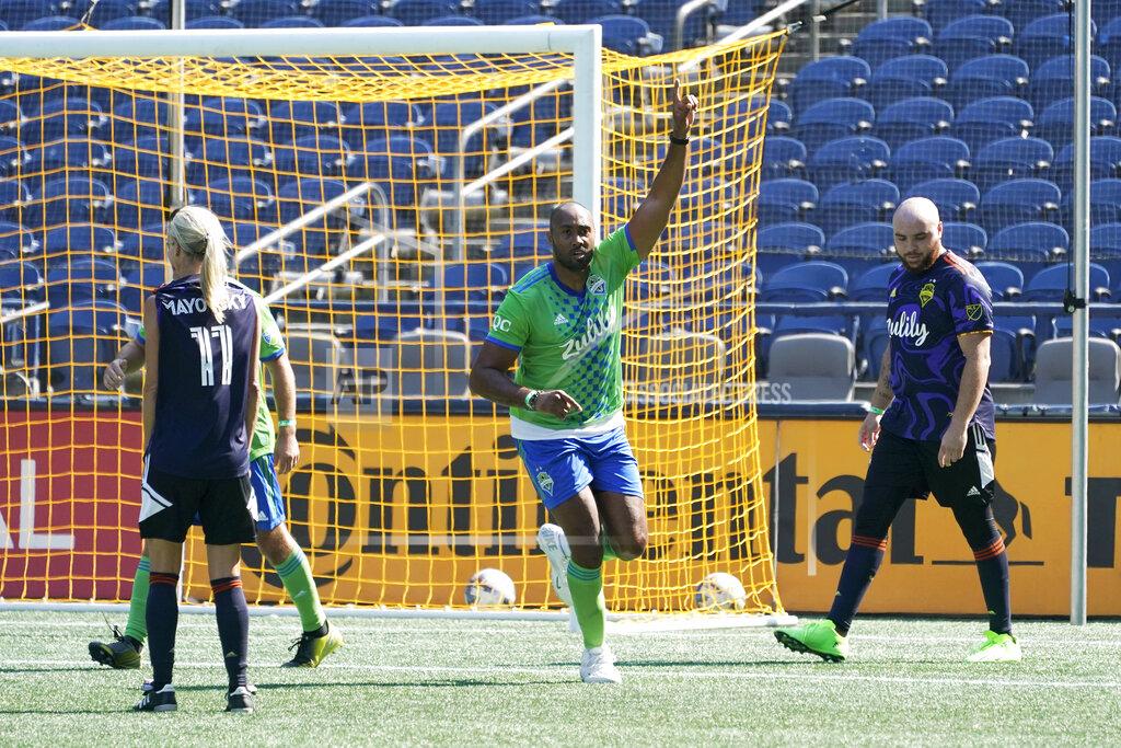 Ted S. Warren Former Seattle Seahawks NFL football linebacker K.J. Wright, center, celebrates after scoring a goal while playing in the MLS soccer Seattle Sounders' media match, Friday, Sept. 2, 2022, in Seattle. The traditional match gives journalists who cover the team during the season a chance to show their skills on the pitch. (AP Photo/Ted S. Warren)