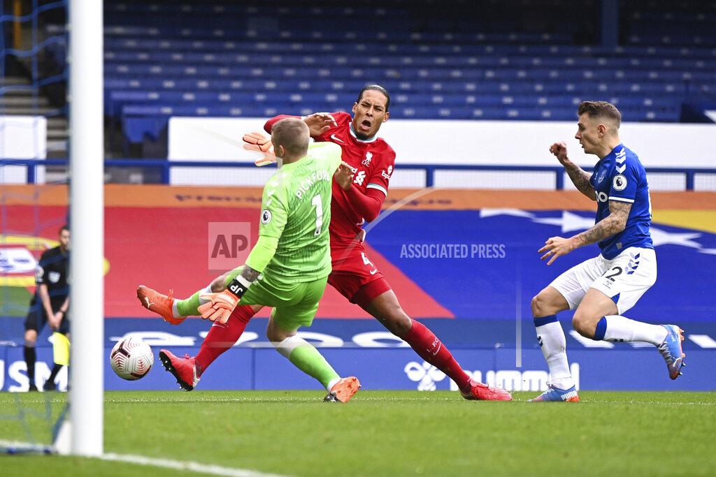 Laurence Griffiths Liverpool's Virgil van Dijk, centre, is tackled and injured by Everton's goalkeeper Jordan Pickford, left, causing him to leave the match injured during the English Premier League soccer match between Everton and Liverpool at Goodison Park stadium, in Liverpool, England, Saturday, Oct. 17, 2020. (Laurence Griffiths/Pool via AP)