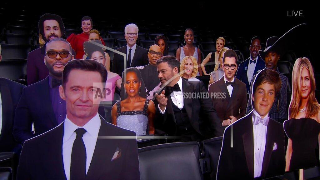 Uncredited This image released by the Television Academy shows host Jimmy Kimmel, center, chatting with a cardboard cut-out of Regina King while surrounded by other celebrity cut-outs during the 72nd Emmy Awards telecast on Sept. 20, 2020 (Invision for the Television Academy via AP)