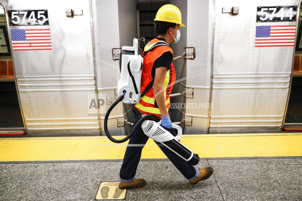 John Minchillo A contractor carries an electrostatic sprayer used to disinfect subway cars at the 96th Street station to control the spread of COVID-19, Thursday, July 2, 2020, in New York. Mass transit systems around the world have taken unprecedented — and expensive — steps to curb the spread of the coronavirus, including shutting down New York subways overnight and testing powerful ultraviolet lamps to disinfect seats, poles and floors. (AP Photo/John Minchillo)