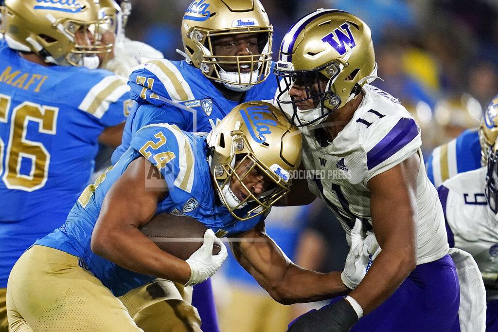 Marcio Jose Sanchez UCLA running back Zach Charbonnet (24) is tackled by Washington linebacker Alphonzo Tuputala (11) during the second half of an NCAA college football game Friday, Sept. 30, 2022, in Pasadena, Calif. (AP Photo/Marcio Jose Sanchez)